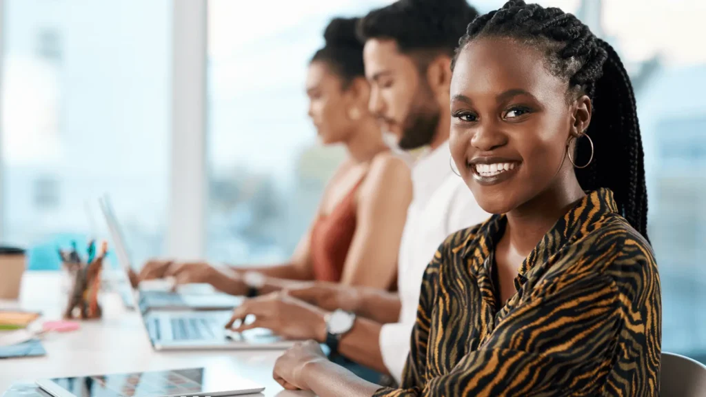 Smiling woman with colleagues in modern office setting.