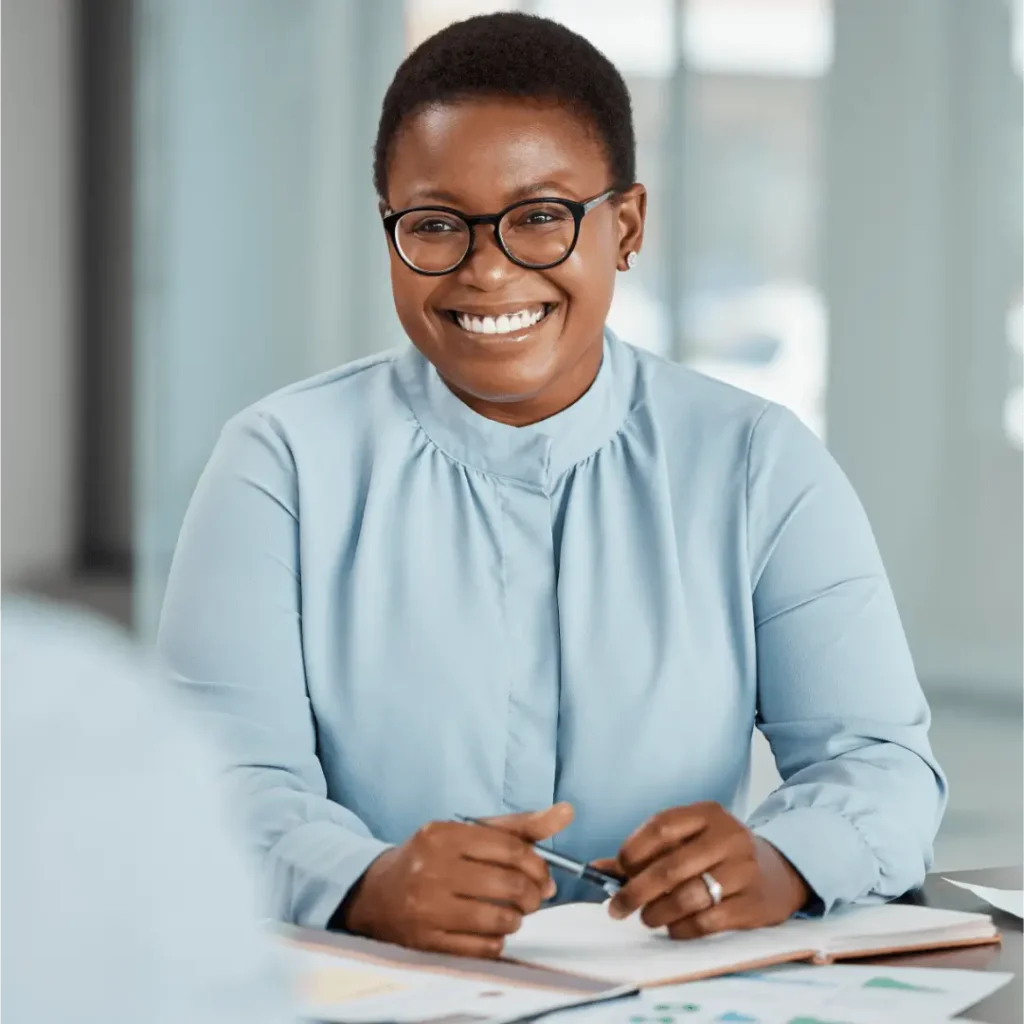 Smiling woman with glasses at business meeting.